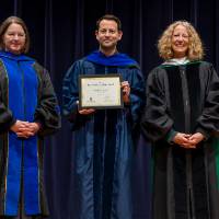 Faculty awardee posing with Provost Drake and Christine